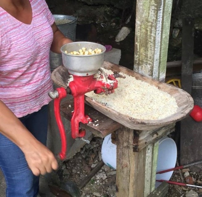 a manual crank corn grain grinder used to grind corn