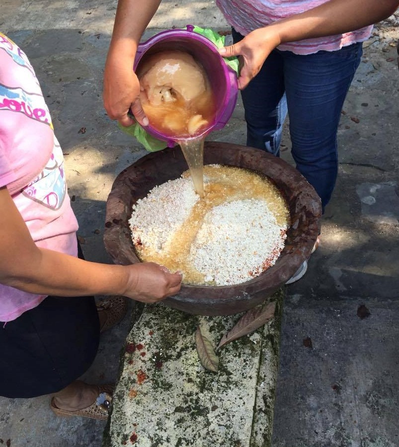 pouring lard into the masa corn