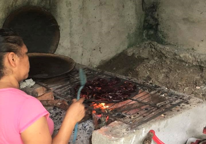 roasting a variety of dried chiles on a comal (skillet) prior to making the sauce