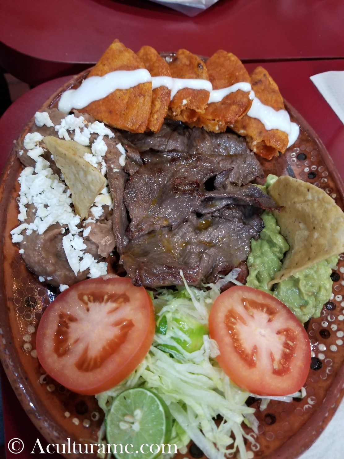 Traditional Enchiladas Potosinas with cecina, guacamole and refried beans.