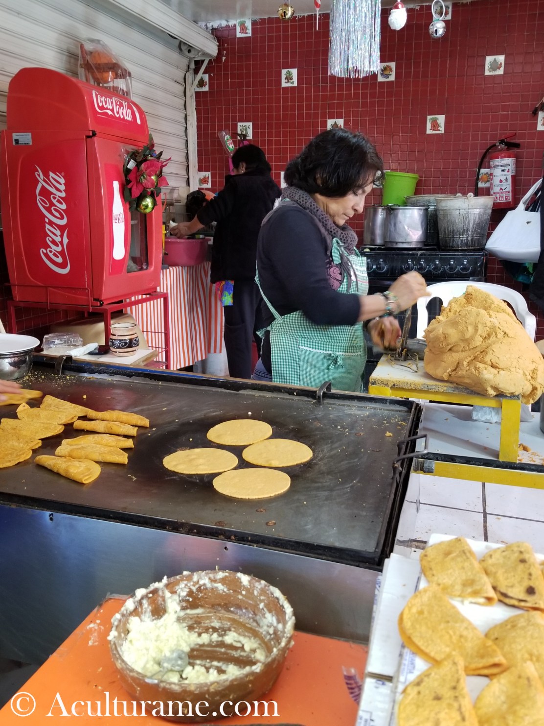 A woman preparing traditional enchiladas potosinas from scratch.